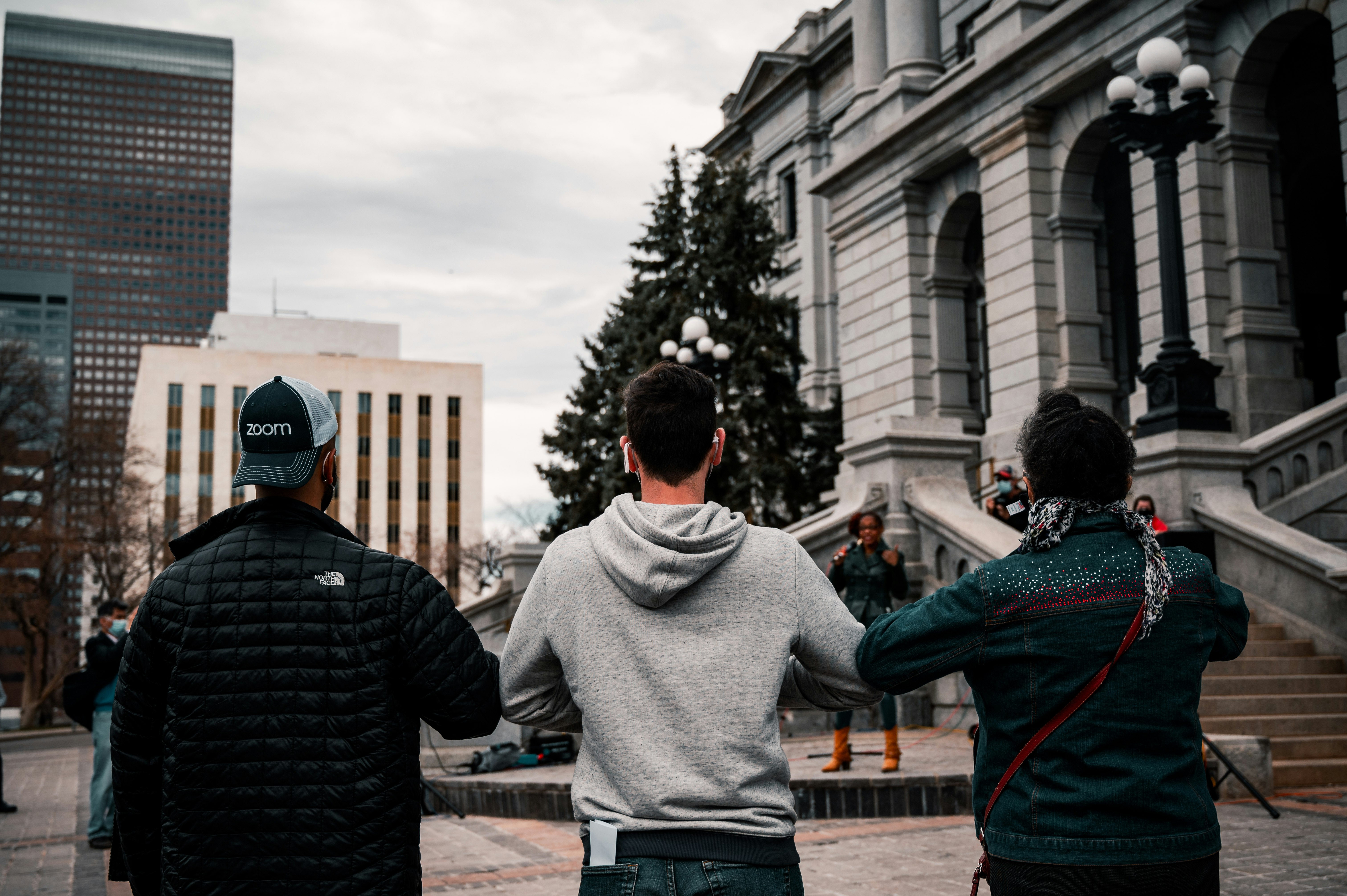 man in gray sweater standing in front of man in black jacket